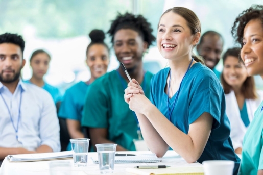 A group of people in scrubs smiling

Description automatically generated